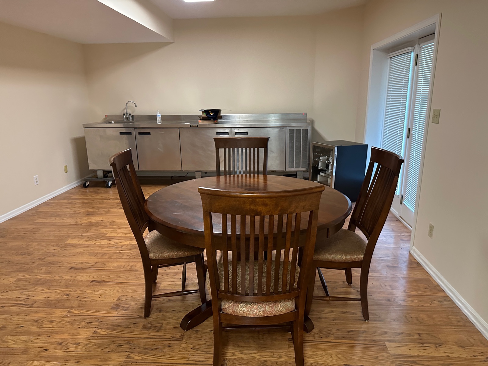 Basement bar area with large stainless sink and refrigerator unit