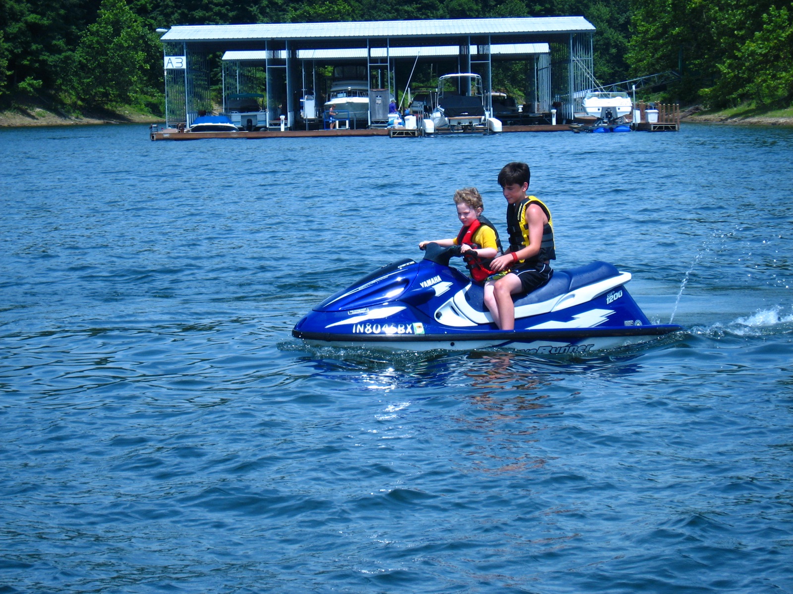 Drew and Alex on a wave runner in front of the boat docks