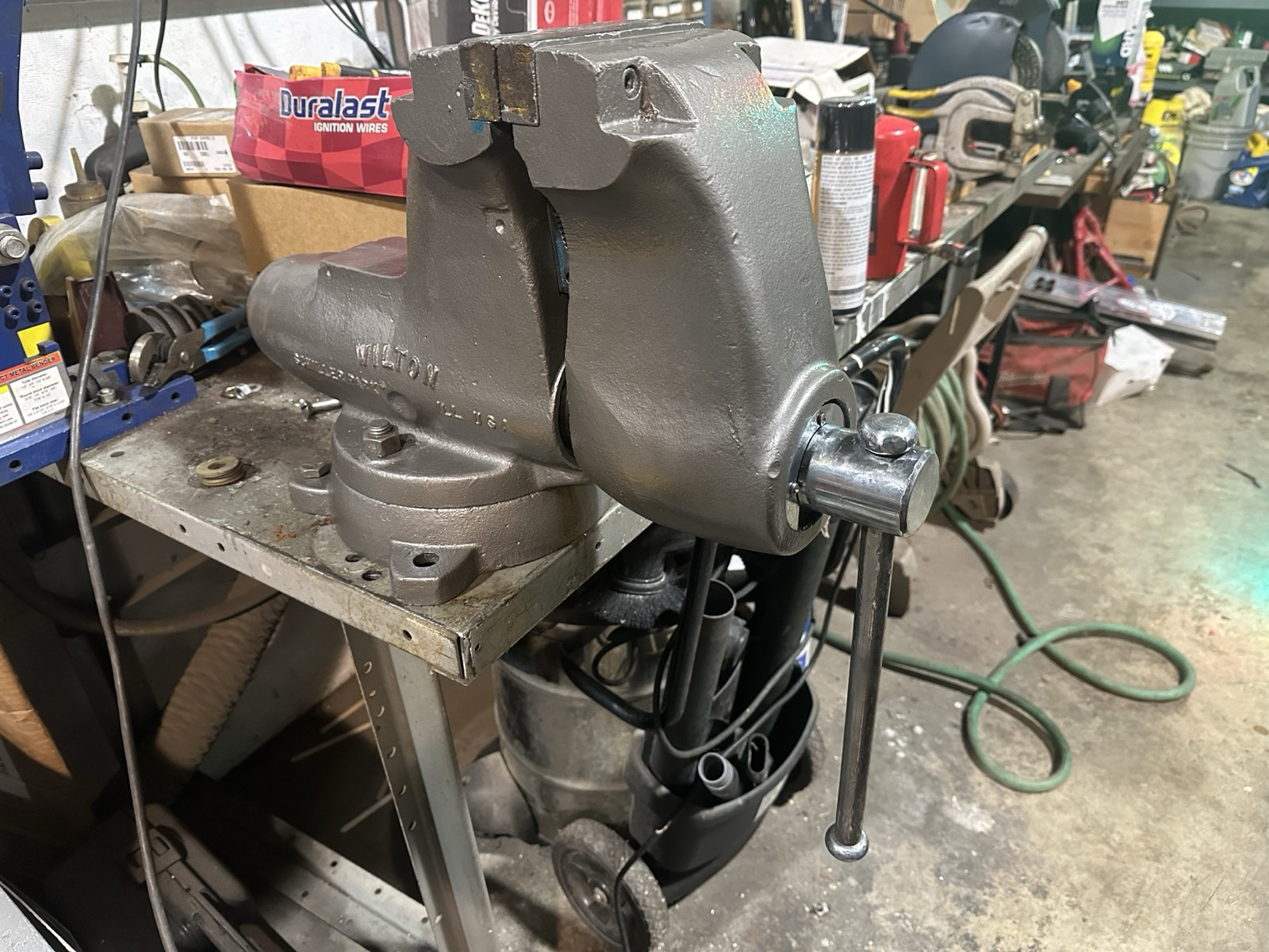 A large six-inch Wilton bench vise mounted on a steel work table in Eric's shop